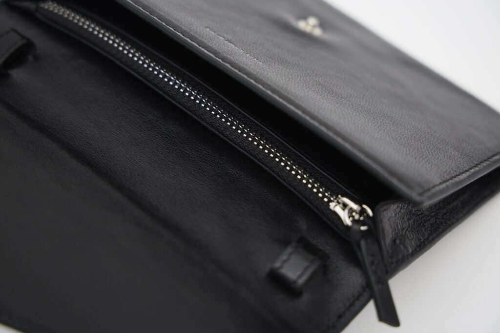 ジップ付きポケットで仕切られた収納スペースのほか、2枚入るカードスロットも。 ジップ付きポケットで仕切られた収納スペースのほか、2枚入るカードスロットも。