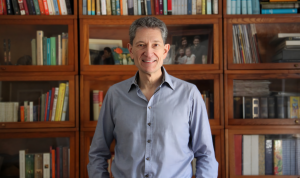 David Earn, a member of the Michael G. DeGroote Institute for Infectious Disease Research, stands in front of a bookcase.