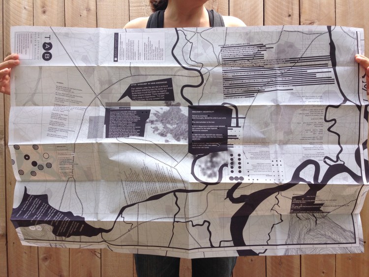 Holding a 24 x 36 map with text orientated in different directions on top of pathways, street line, rivers, and a longitude/latitude grid. Printed with one color, dark blue.