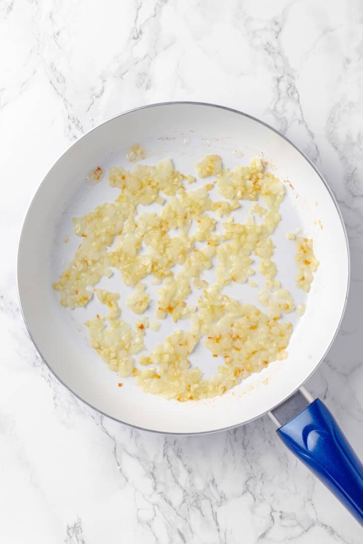 This baked spaghetti is pure comfort food for pasta lovers! Tender eggplant, vegan ground beef and lots of cheese makes it irresistible. Overhead view of onion cooking in skillet