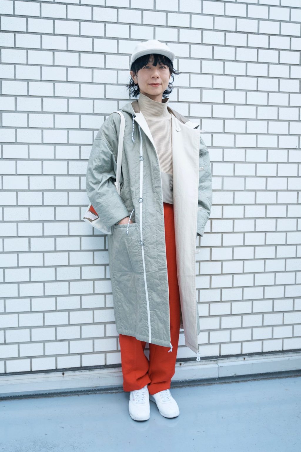 スニュウ デザイナー 雪浦聖子さんの私服ファッションスナップ。淡色トーンに赤をひとさじ。軽やかなキルティングコートで楽しむ冬コーデ