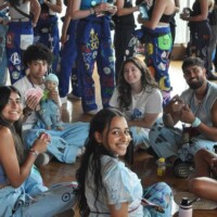 Faculty representatives and first-year students sitting in a circle playing cards.