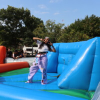 A faculty representative posing with peace signs on an inflatable.