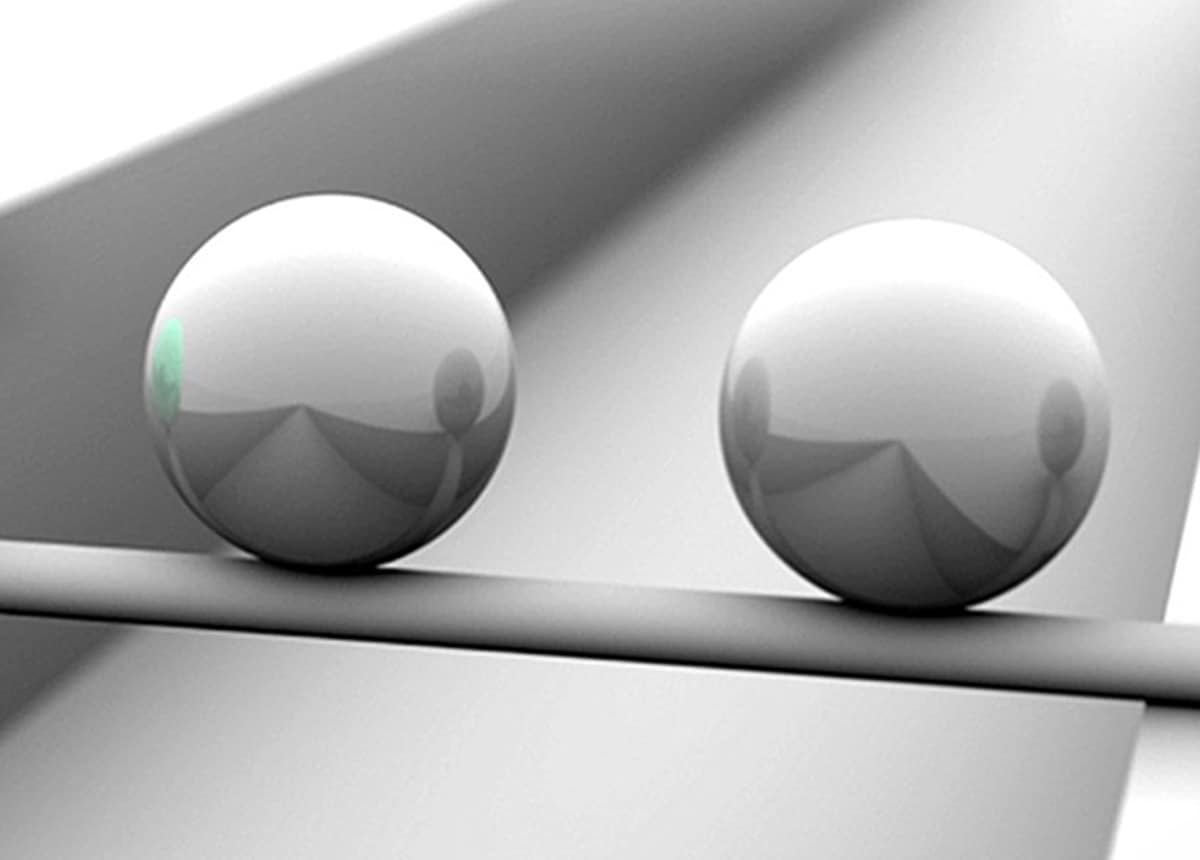 Illustration of Persuasion Techniques Image of two metal spheres on a reflective surface, used to illustrate persuasion techniques.