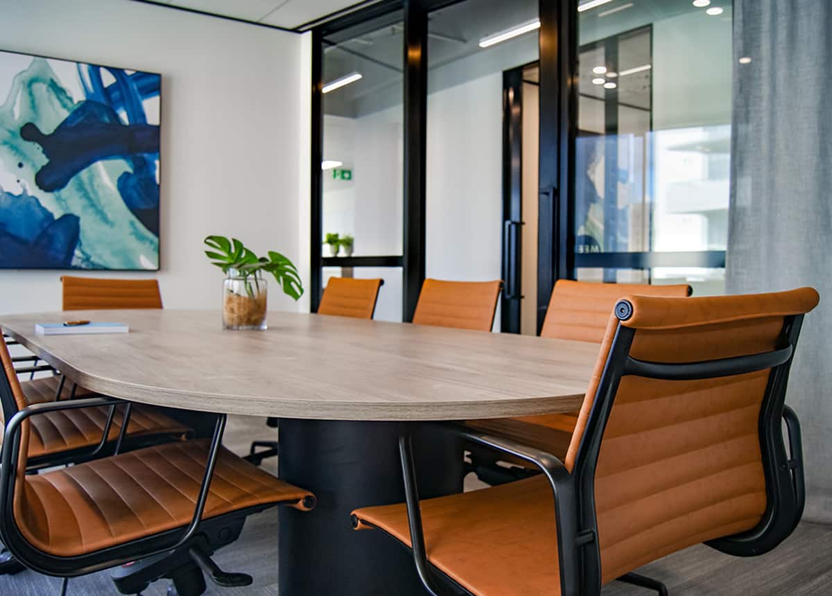 Modern Office Conference Room Modern conference room with leather chairs around a wooden table, featuring a large abstract painting on the wall.