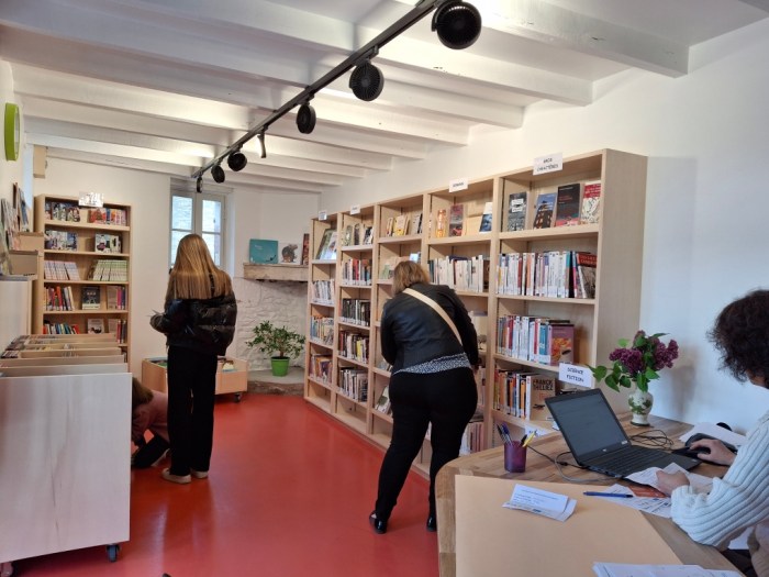 Two people looking through bookshelves.