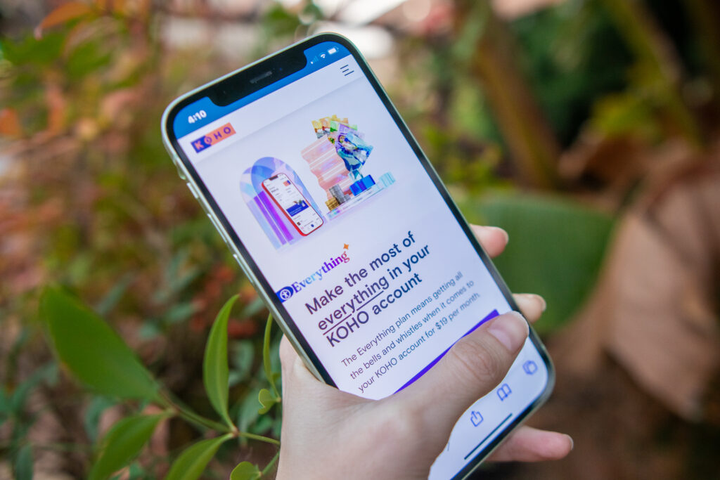 Woman's hand holding a phone that displays KOHO app banking plans