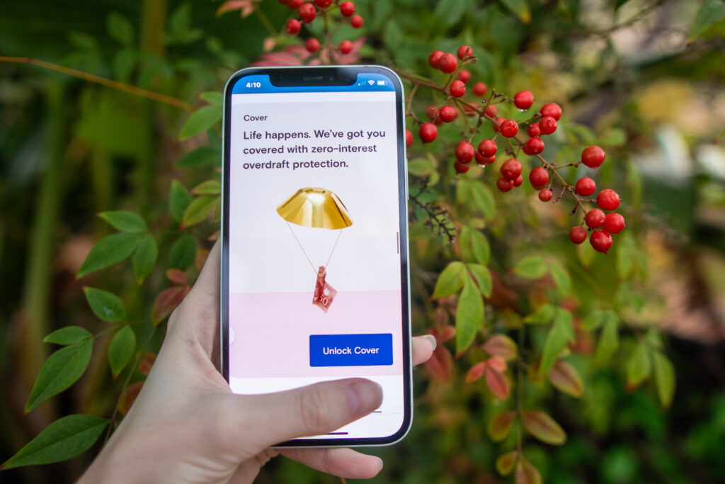 Woman's hand holdng a phone that displays a promo for Super cash advances