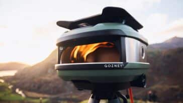 First Look: New Gozney Tread Pizza Oven Pizza Oven An olive color Gozney Tread pizza oven with a fire burning inside and a mountain in the background
