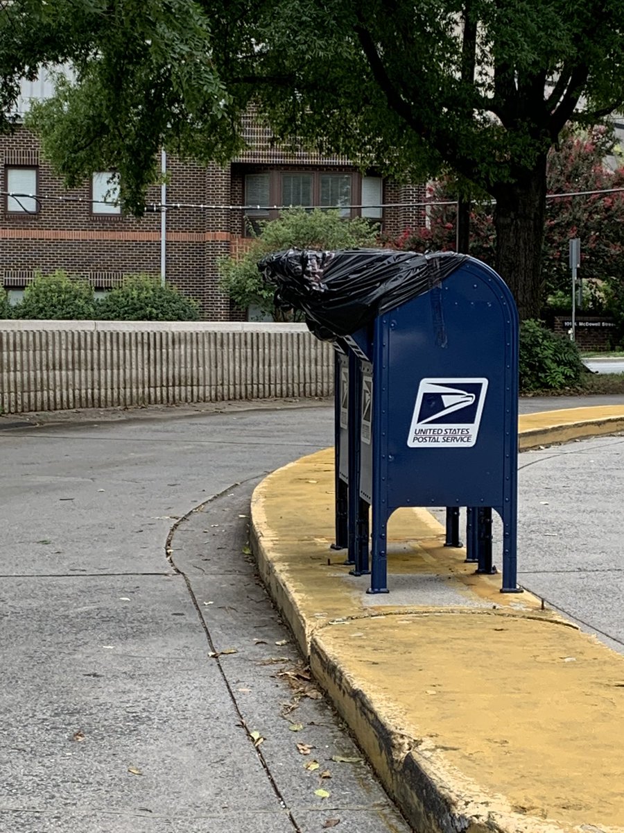 Two more blue post office boxes with trash bags covering the mail slot