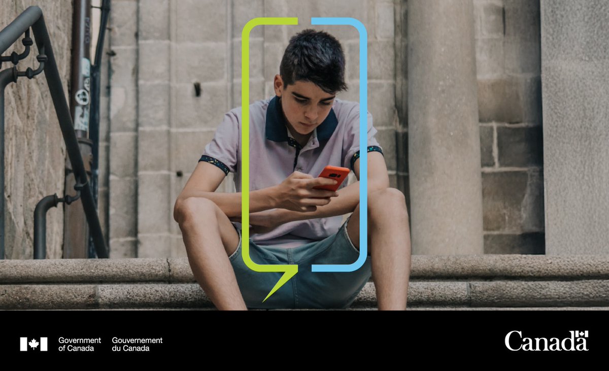 Young child sitting on steps, looking at his phone.