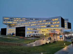 Early morning. Building with where the lights are on.