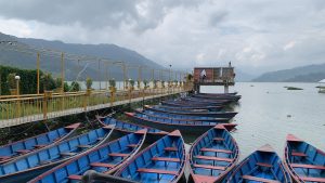 blue wooden boat on lake water taken at daytime