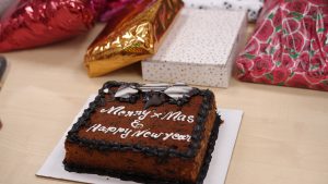 Some Gift-packs and a Cake with Christmas and New Year wish written on it.