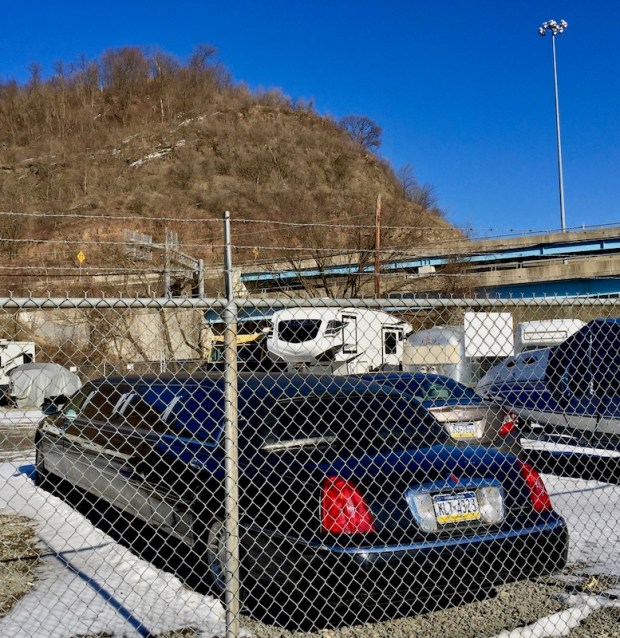 limousine parked inside storage yard surrounded by chain link fence