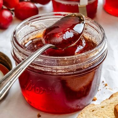 Completed Easy Grape Jam (No Pectin) in a jar with a spoonful of jam.