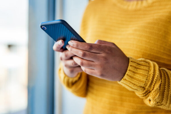 Shot of an unrecognizable woman using a mobile phone indoors Shot of an unrecognizable woman using a mobile phone indoors