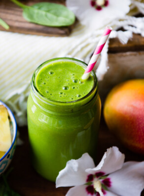 Pink and white striped straw in a green smoothie.