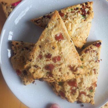 A white plate with ham and cheese scones on it.
