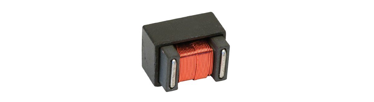 A rectangular electronic component with a black casing and visible copper wire coil wrapped around its center, likely a power inductor or high frequency transformer, isolated on a white background. by Standex Edge