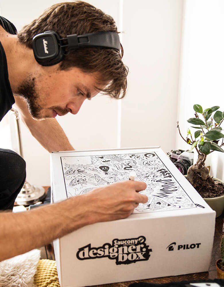 Personne dessinant des graphismes sur sa boîte Saucony
