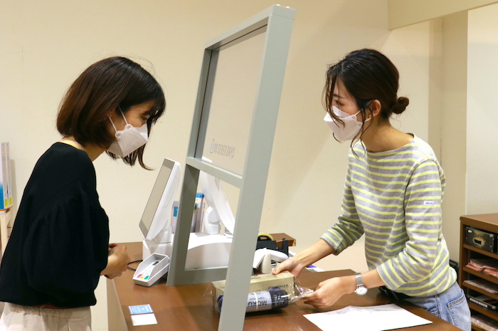 店舗受取のようす。カウンターで顧客と一緒に商品を確認し、ラッピングした上で受け渡す