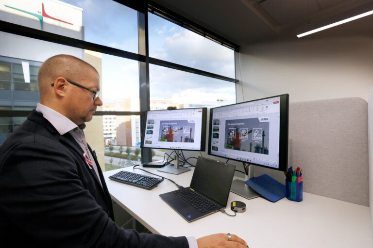 Mies tekee töitä tietokoneella ikkunan ääressä.