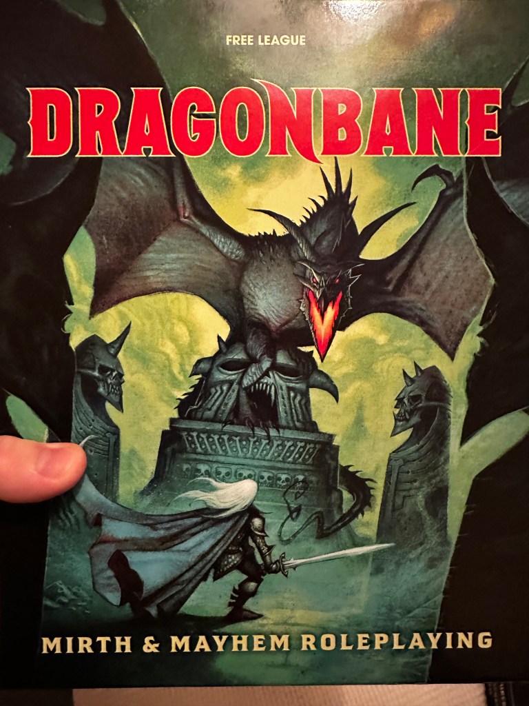 The cover of the Dragonbane boxed set. A dragon menaces a long white haired adventurer on a greeen background