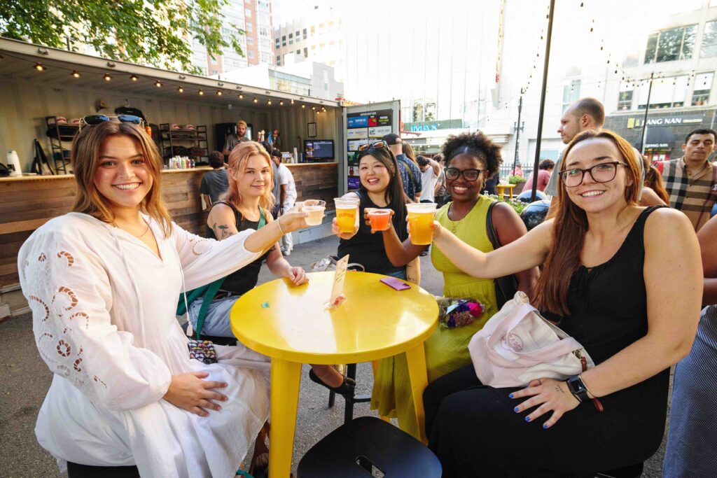 influencers with harpoon beer sitting around yellow table.