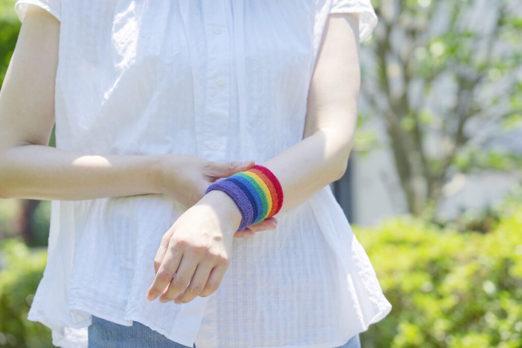 Person wearing an LGBTQ colored wristband