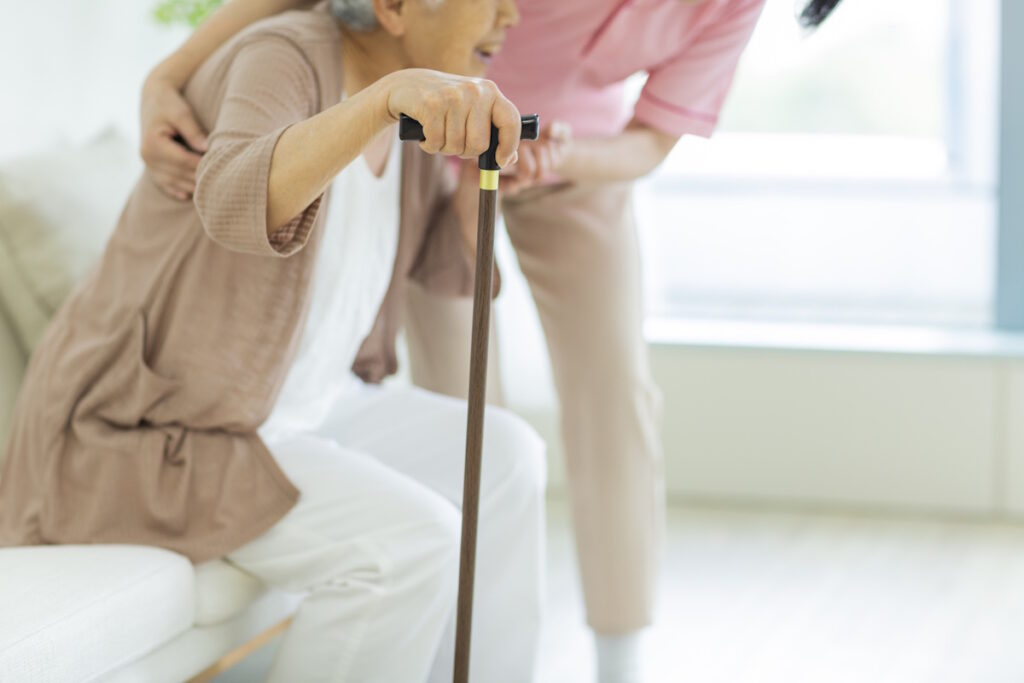 Health care worker helping an elderly woman to stand