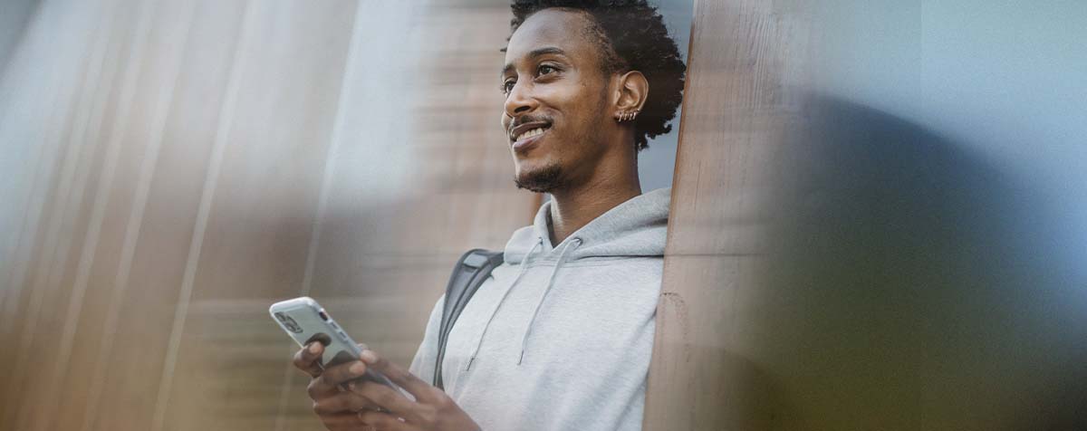 Person lächelt und benutzt ein Telefon