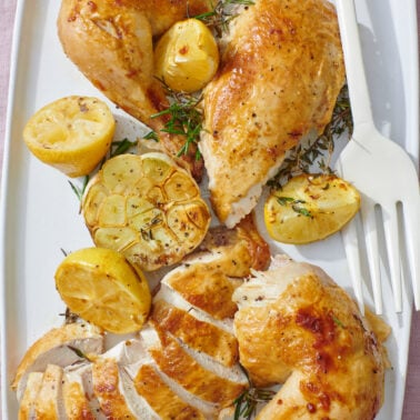 Roast chicken sliced and on a serving platter.