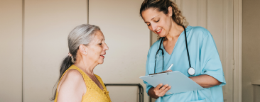 Younger woman with a clipboard talking with an older woman