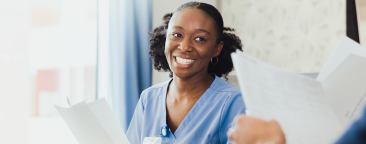 younger woman reading documents, smiling