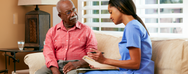 Older man speaking to younger nurse/care giver