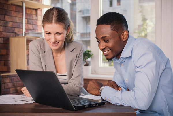 A man and a woman looking at a laptop screen