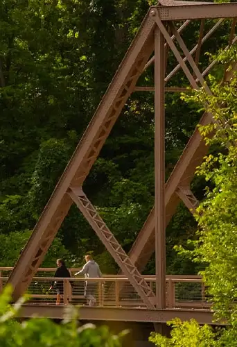 People walking along a river in a park