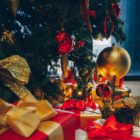 green Christmas tree with decorations and gift boxes on floor