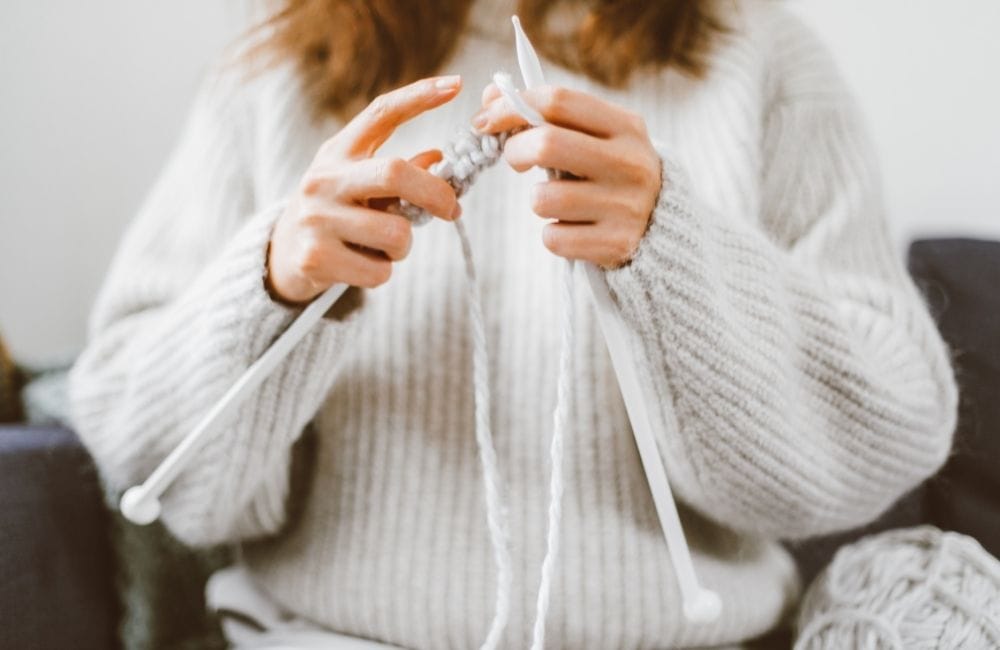 woman with knitting needles casting on knitting stitches