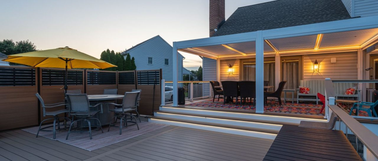 composite backyard deck with covered patio, dining area, and yellow umbrella