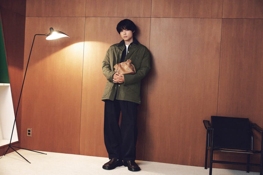 ロエベの2025年秋冬のメンズファッションに身を包み、フラメンコクラッチを胸に抱える松村北斗さん