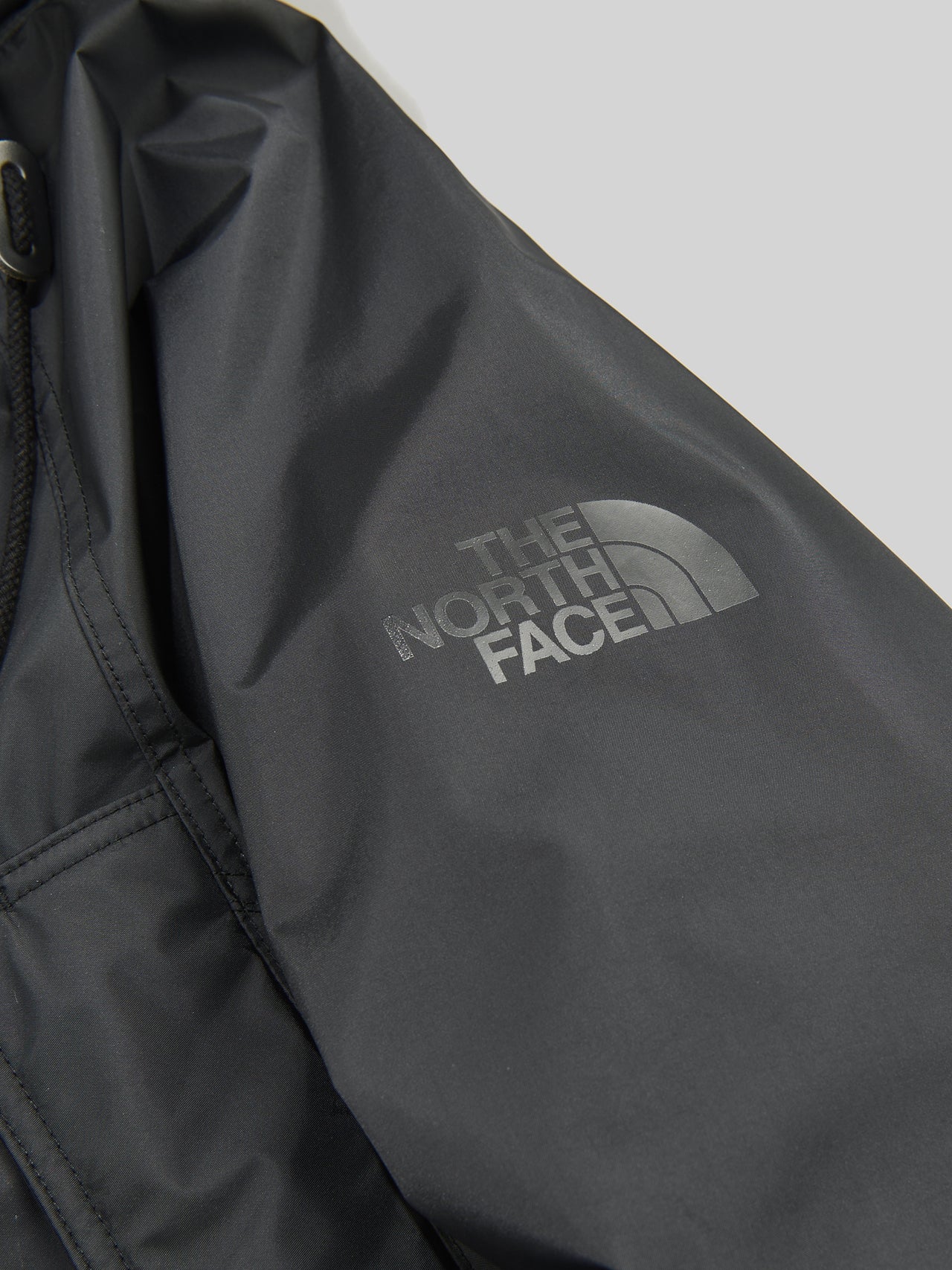 eYe ジュンヤ ワタナベ マンとザ・ノース・フェイスの黒いコラボダウンジャケットの袖ロゴ