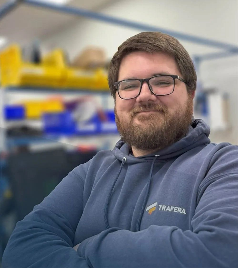 an IT tech standing in a computer repair shop and smiling