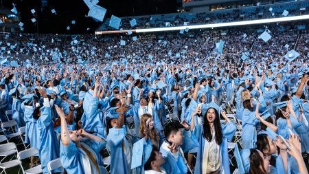 Carolina graduates toss their caps during 2025 Spring Commencement at Kenan Stadium.